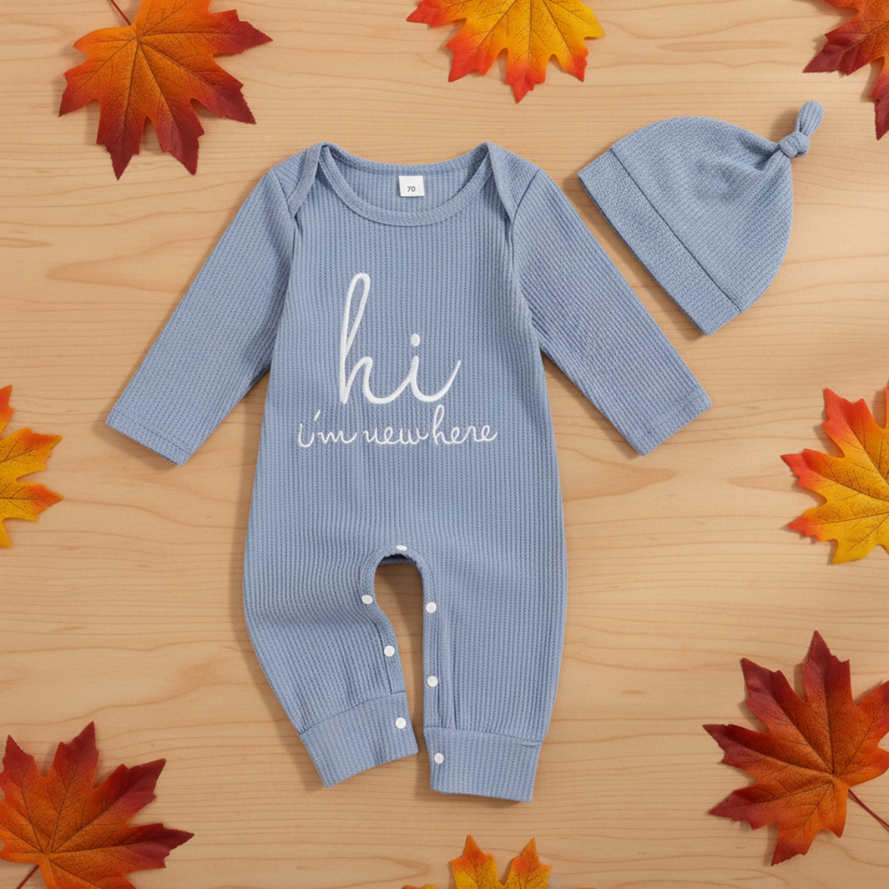 Ljusblå ribbstickad babyoverall med broderad text och matchande knutmössa