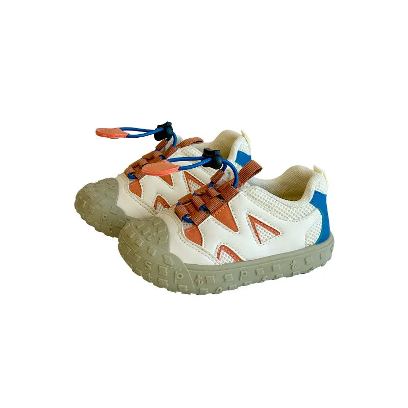 Vita barnsneakers med orange detaljer och gummisula, friställda mot vit bakgrund