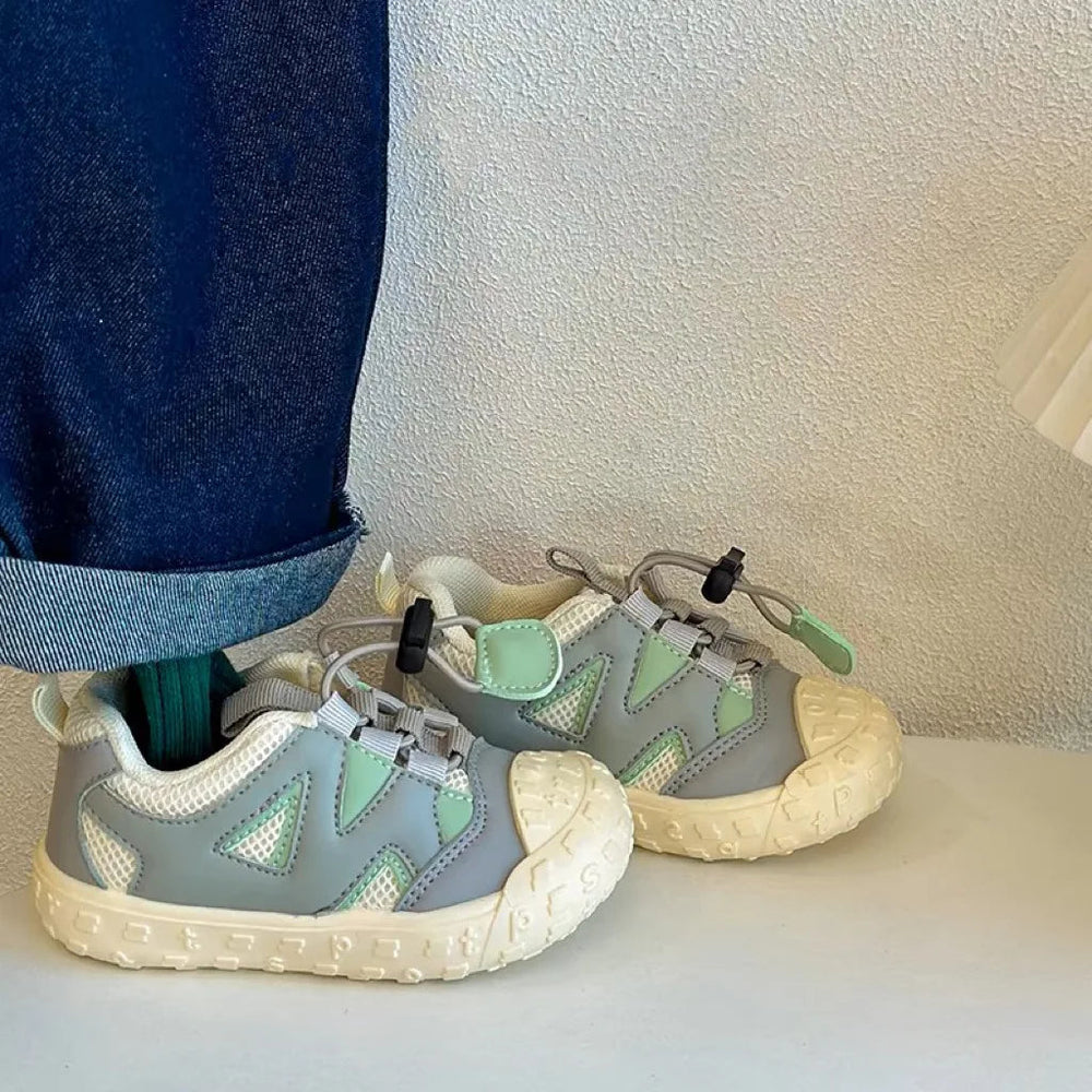 Ljusgröna barnsneakers med meshovandel och ljus gummisula, sedda från sidan